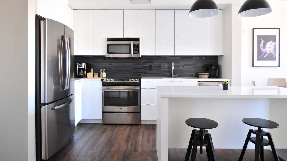 A clean, modern kitchen with white cabinets and stainless steel appliances